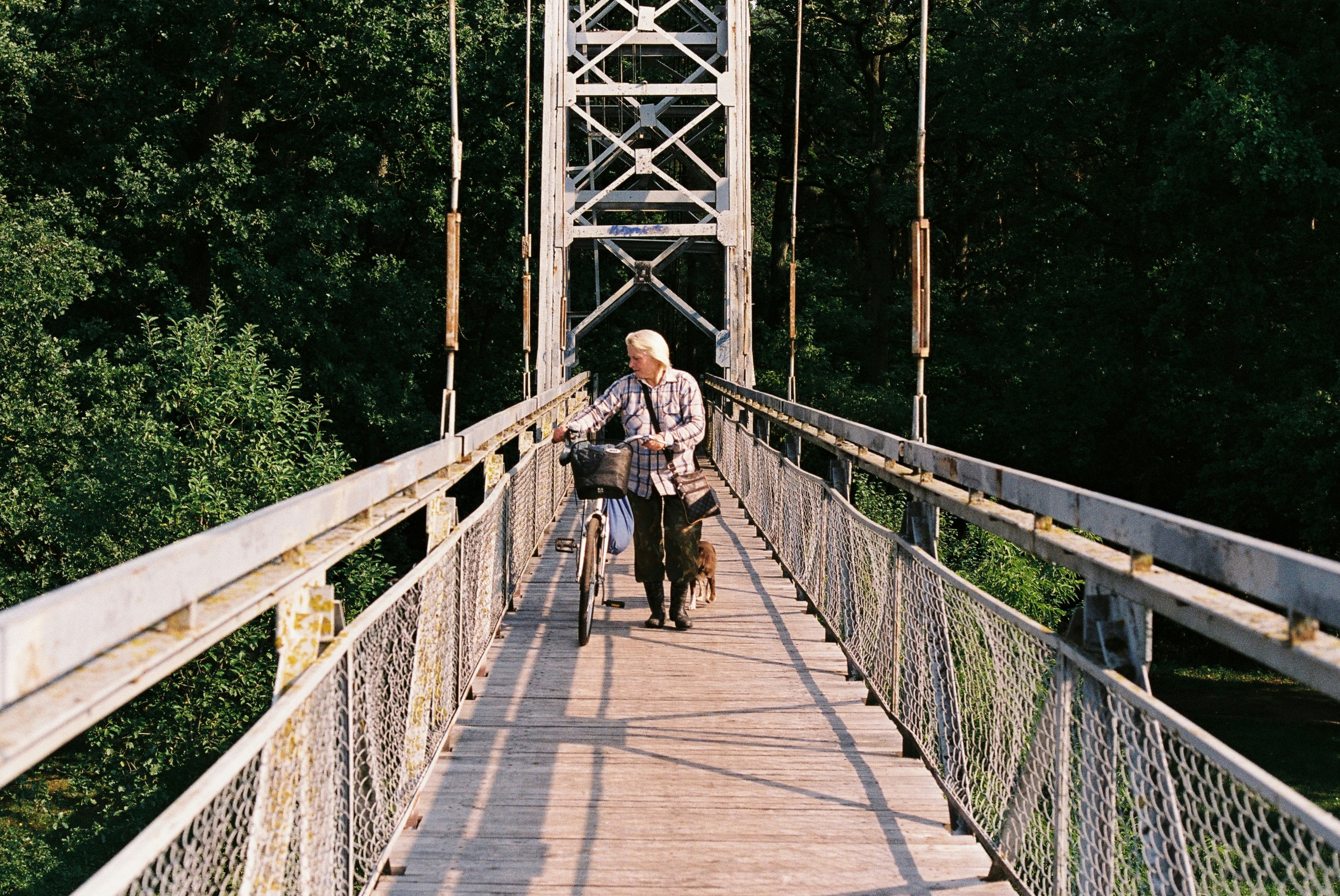 a man riding a bike across a bridge