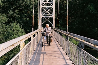 a man riding a bike across a bridge