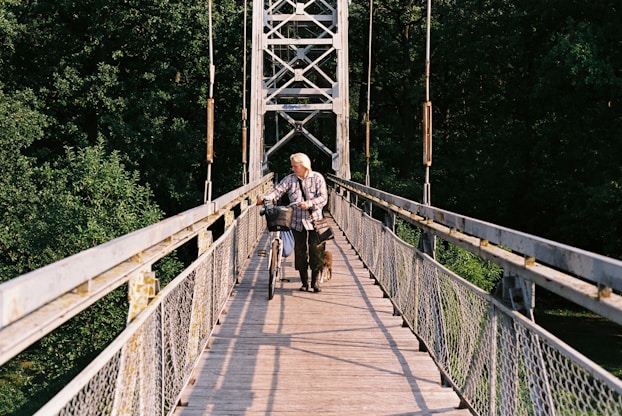 a man riding a bike across a bridge