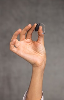 a hand holding Hearing Aids