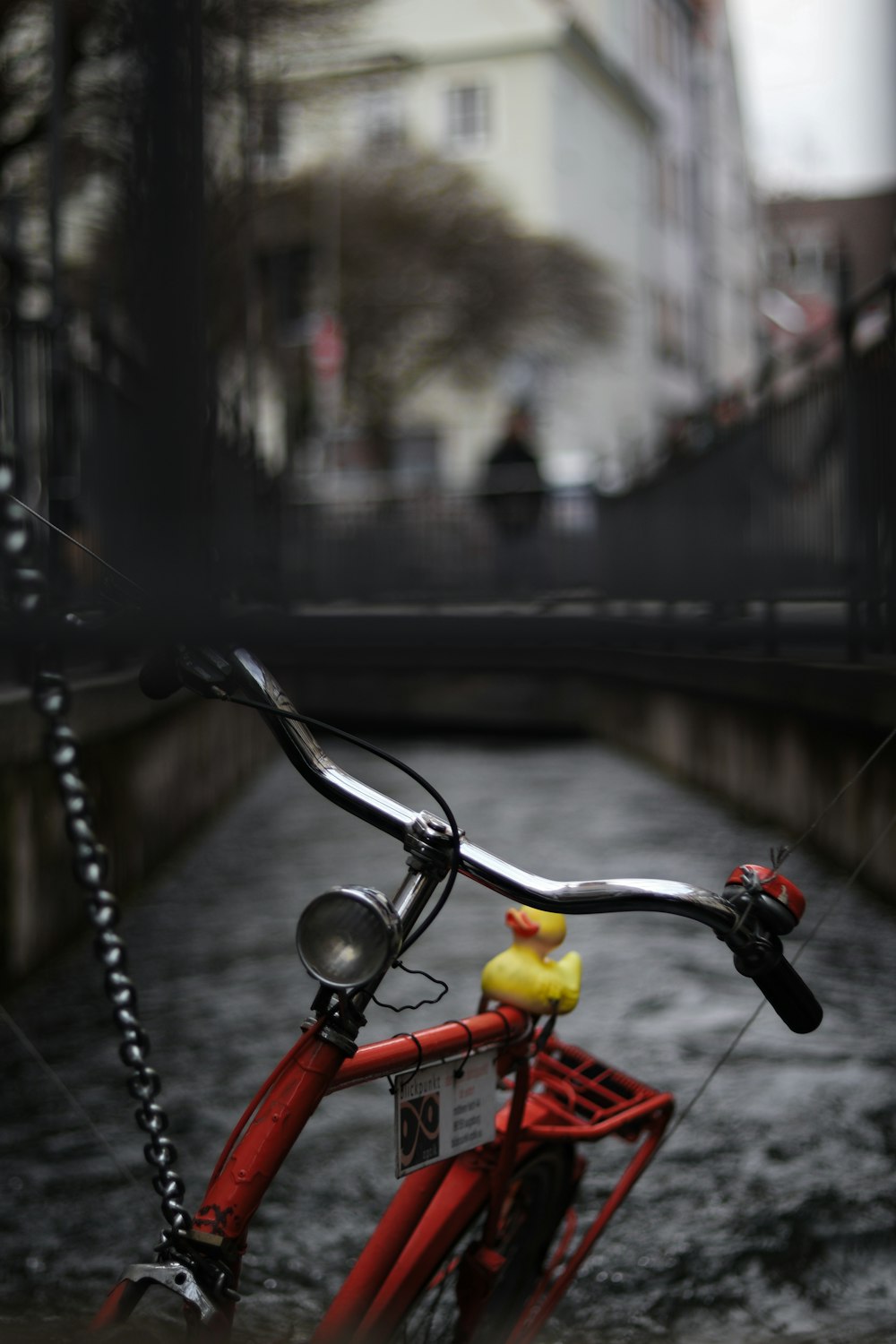 a red bike parked on the side of a river