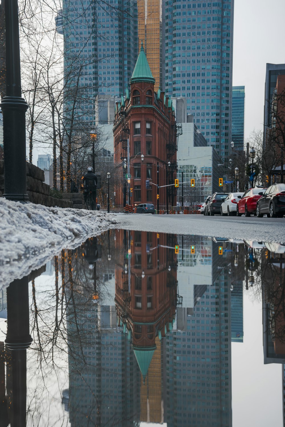 a reflection of a building in a puddle of water