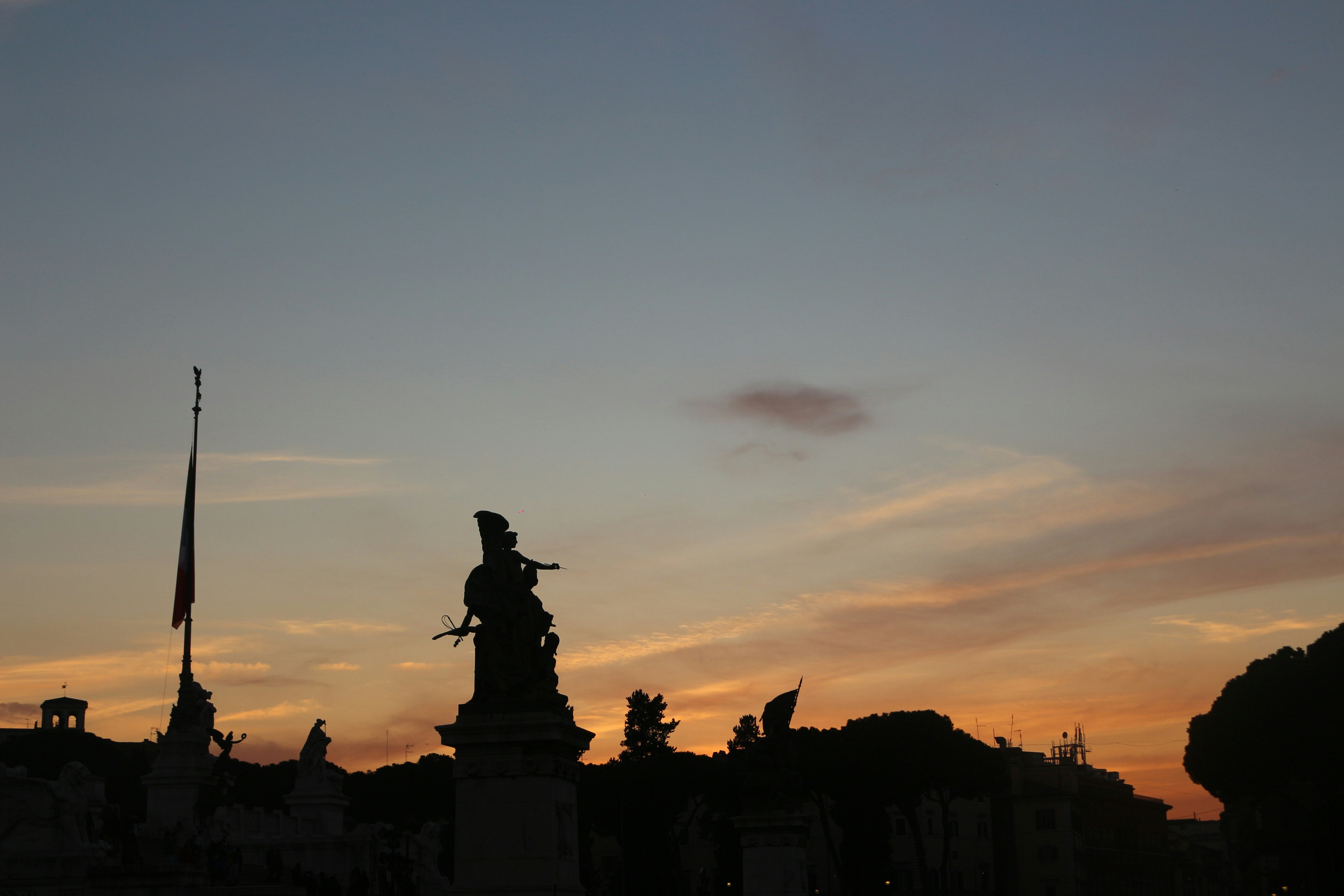 a silhouette of a statue in front of a sunset, Sunset in Rome. The greatness of the Roman Architecture.