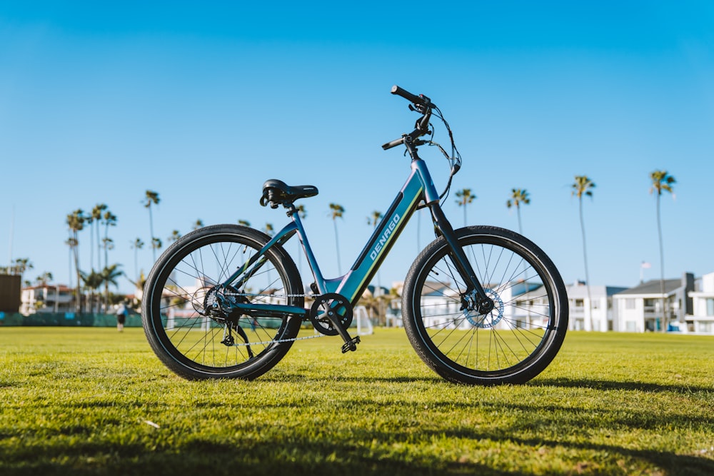 a blue bike parked on top of a lush green field