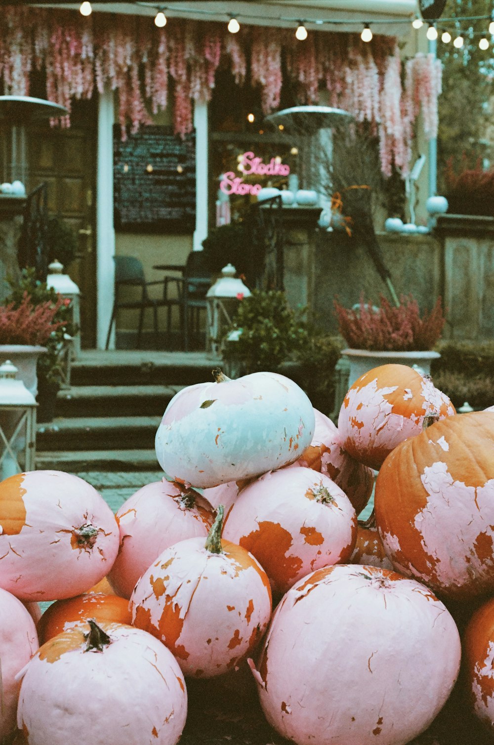 a pile of pumpkins sitting outside of a house
