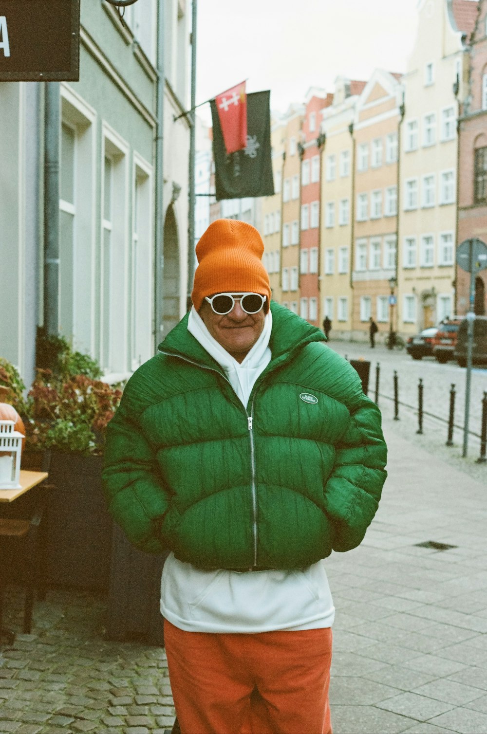 a man wearing a green jacket and orange pants