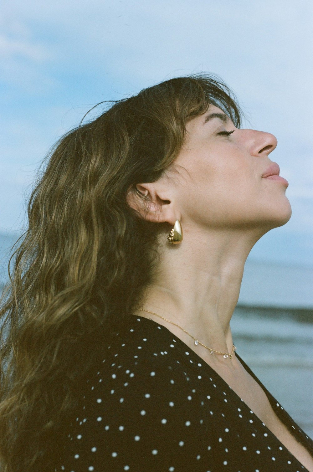 a woman looking up at the sky with her eyes closed