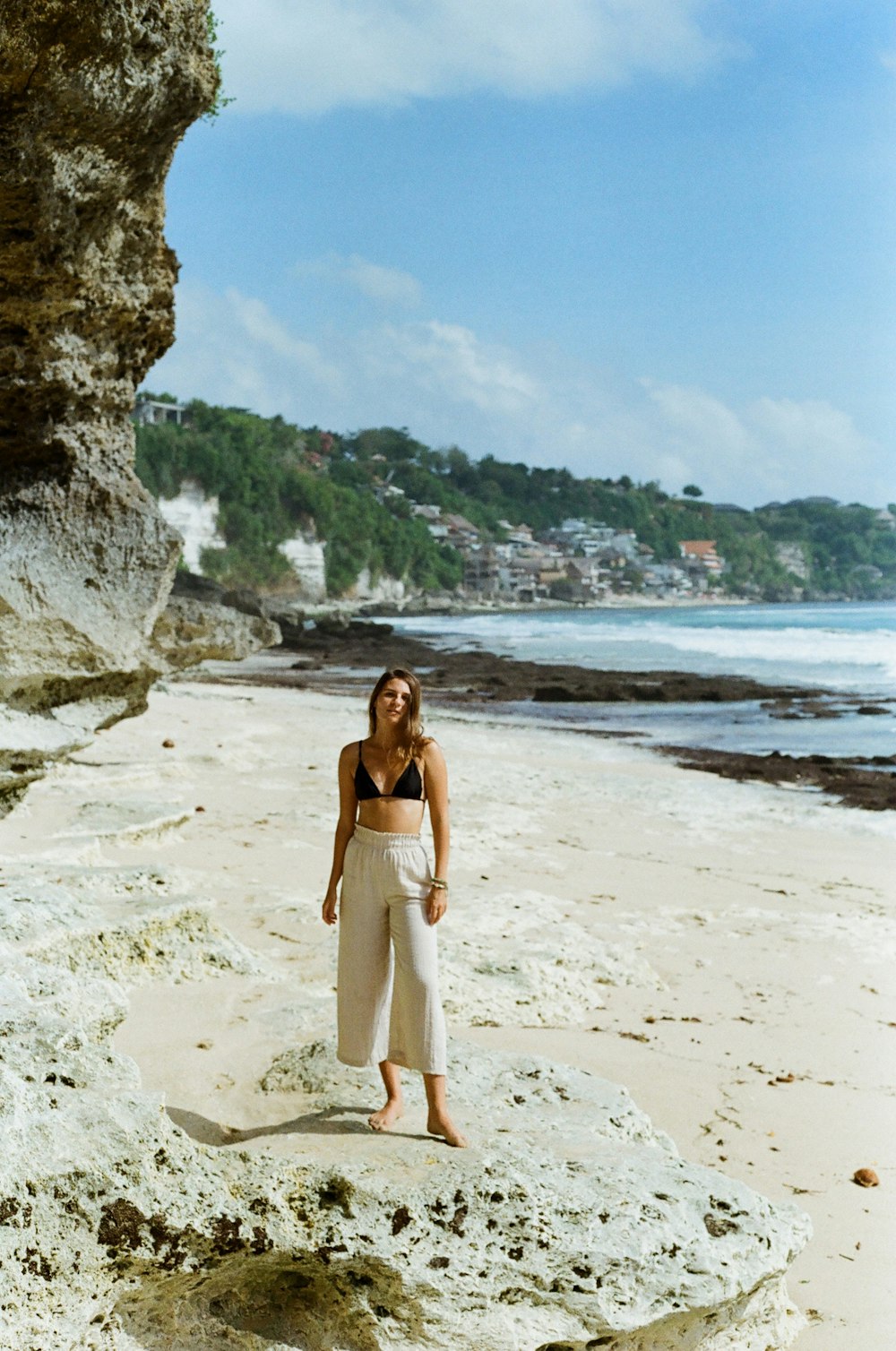 a woman standing on top of a sandy beach