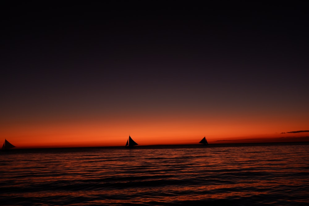 a group of sailboats floating on top of a body of water