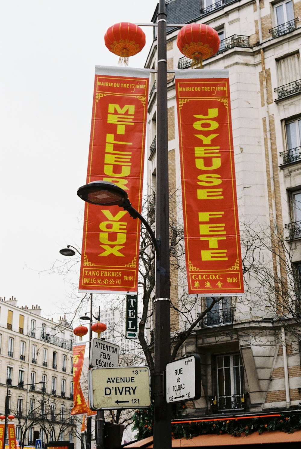 a street light with banners hanging from it's sides