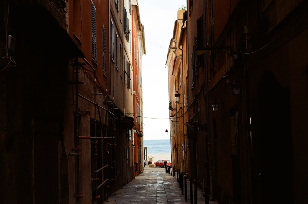 a narrow alley way with people walking down it