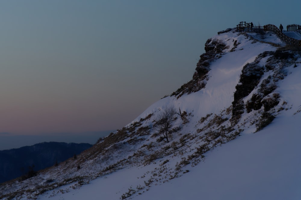 una montagna innevata con persone in piedi in cima