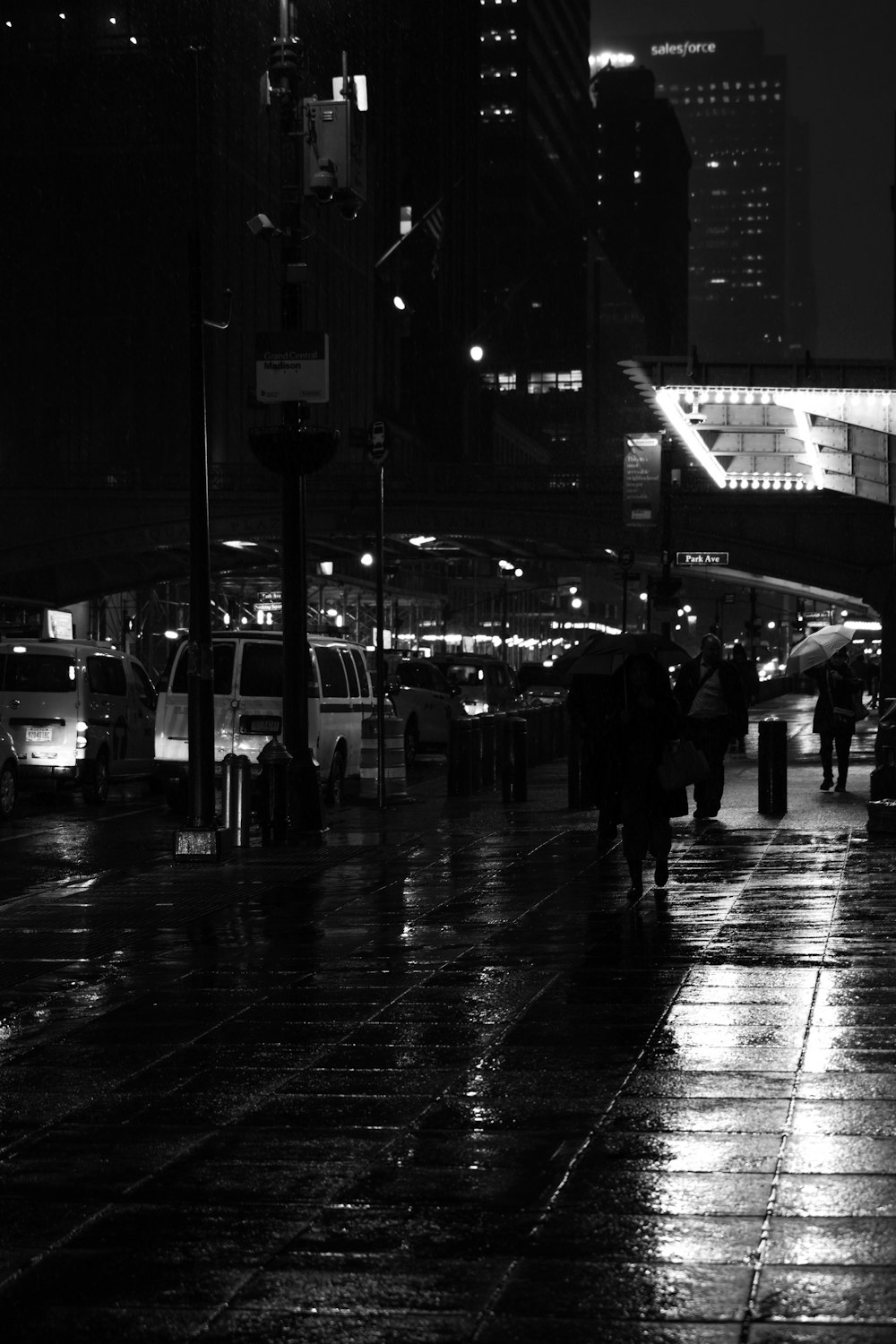 a black and white photo of a city street at night