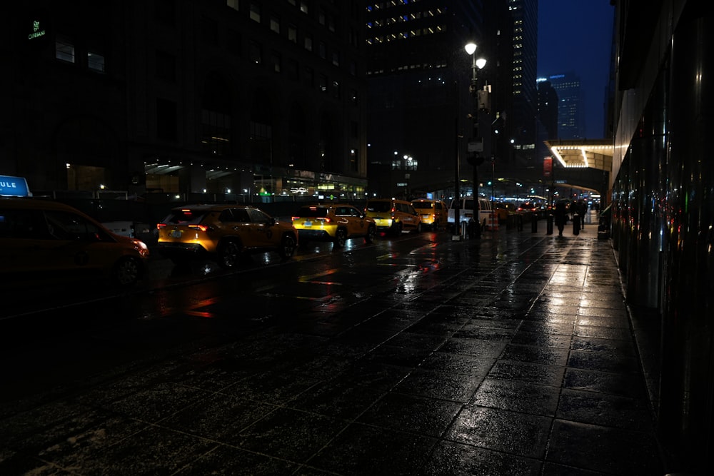 a group of people walking down a street at night