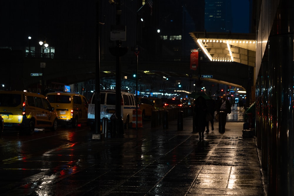 a group of people walking down a street at night