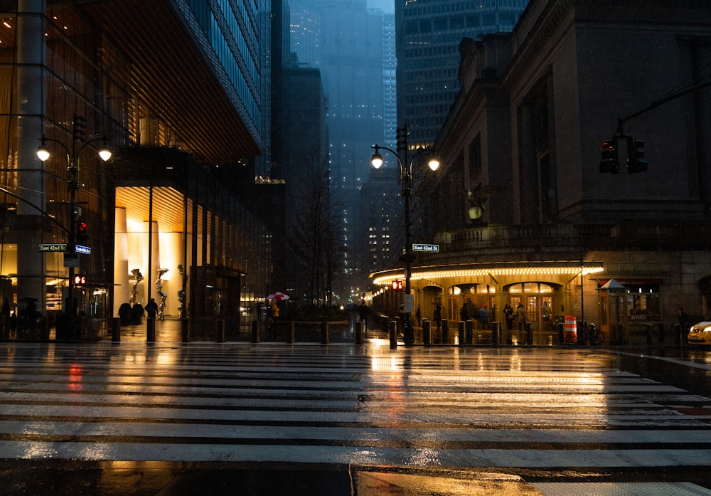 una calle de la ciudad por la noche con gente cruzando la calle