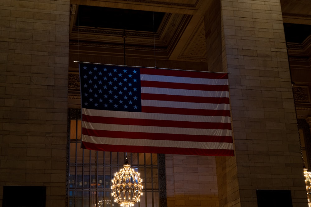 a large american flag hanging from the ceiling of a building