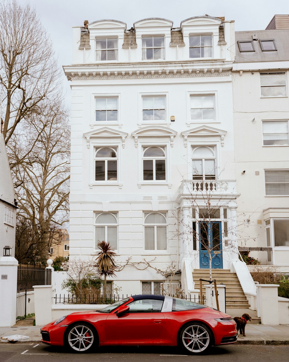 a red sports car parked in front of a white building