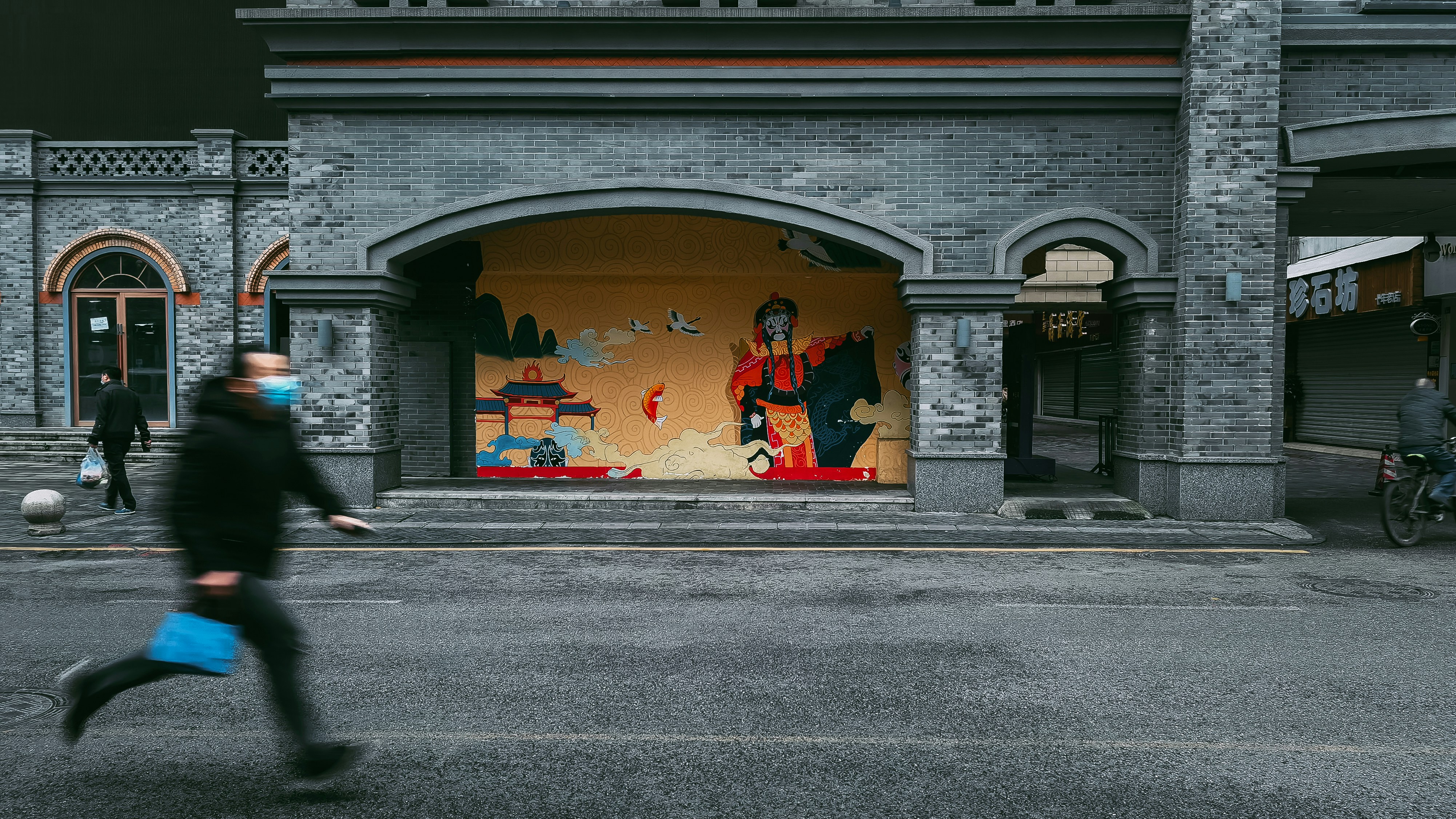 a man walking down a street past a store front
