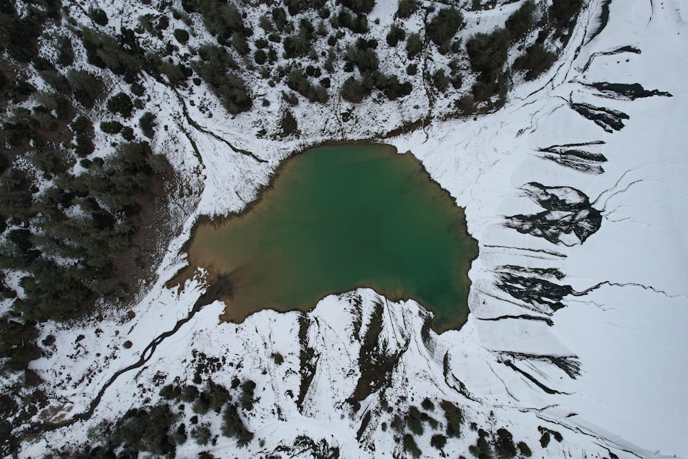 an aerial view of a lake surrounded by snow