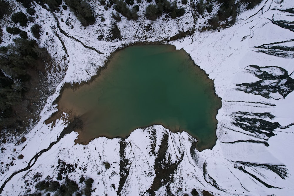 an aerial view of a lake surrounded by snow