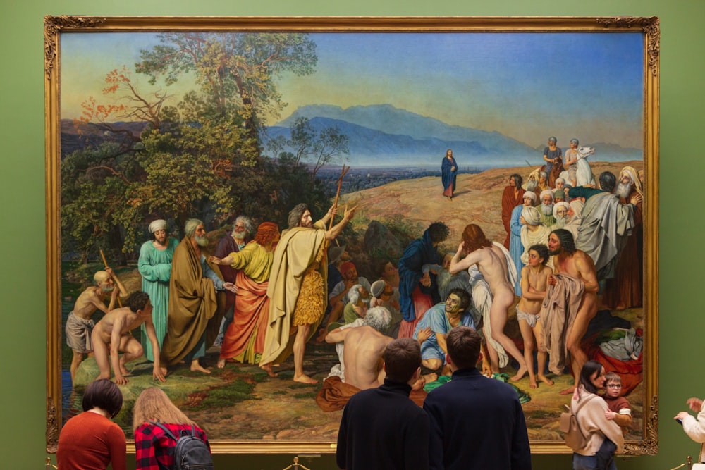 a group of people standing in front of a painting