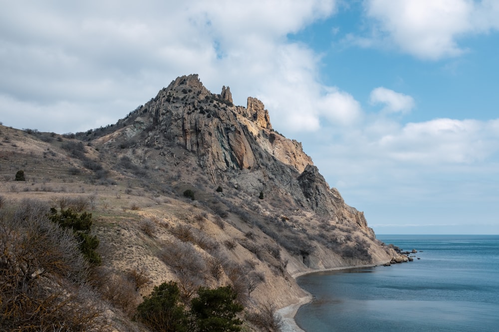 a large mountain with a body of water below it