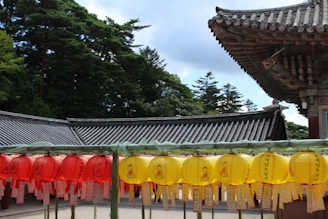 a row of yellow and red lanterns in front of a building