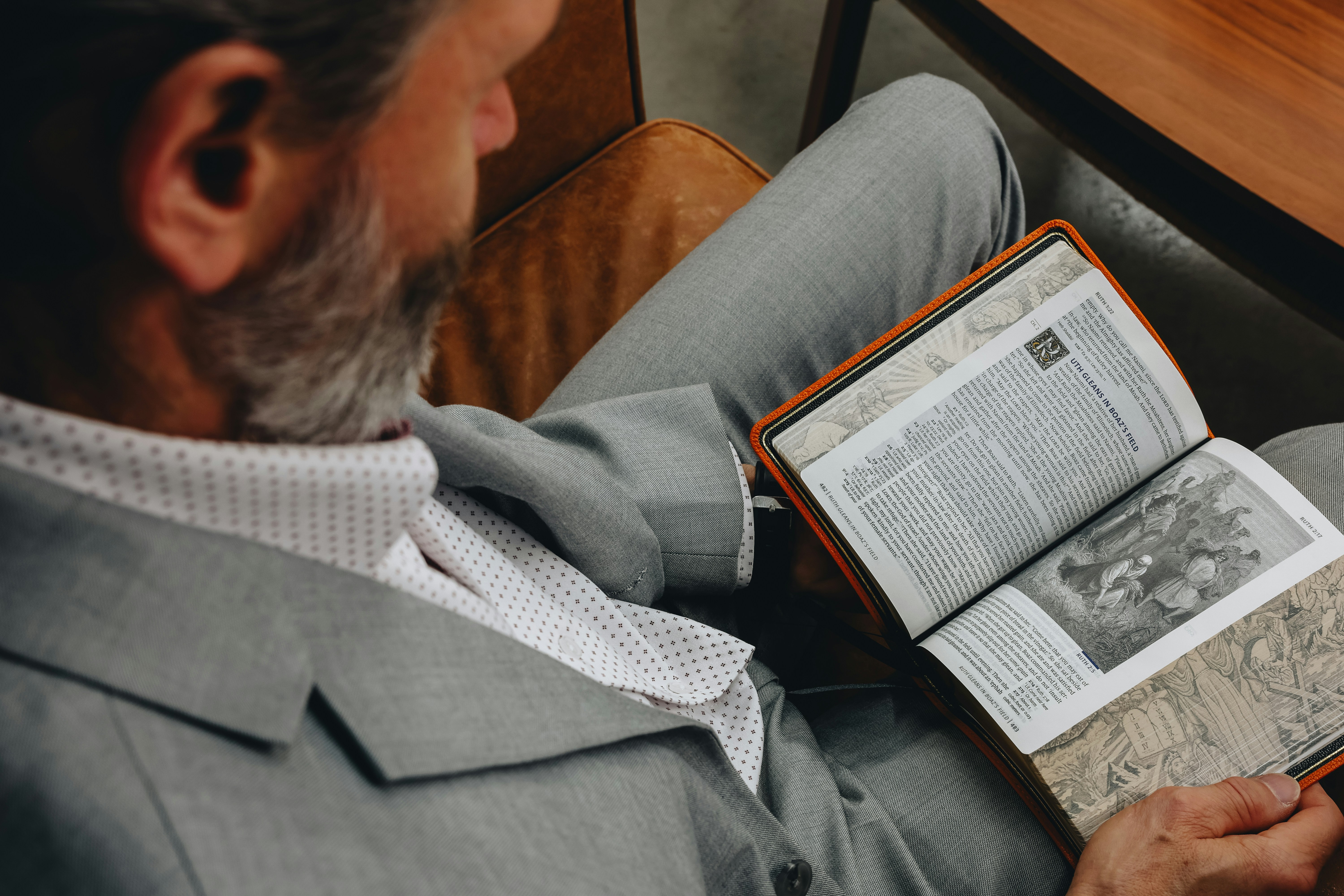 Person reading book in chair