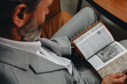 A man sitting in a chair reading a book