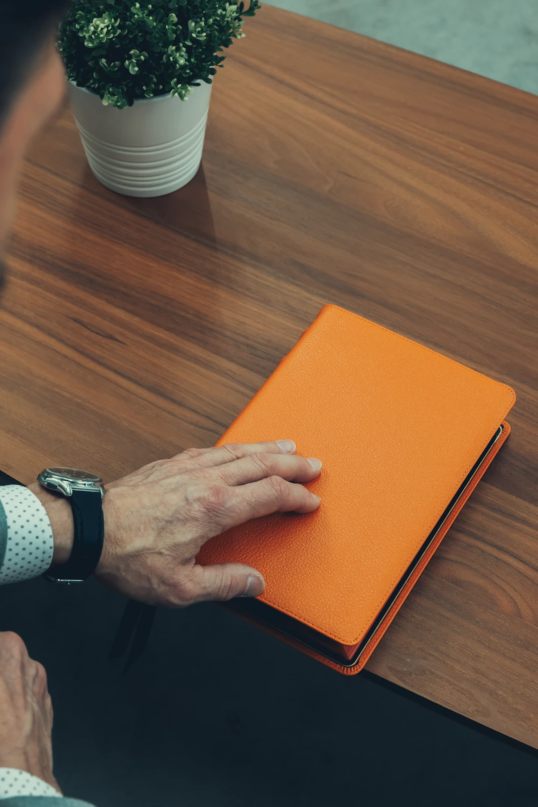 A person studying with an orange notebook