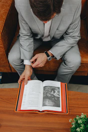 A man sitting on a couch reading a book