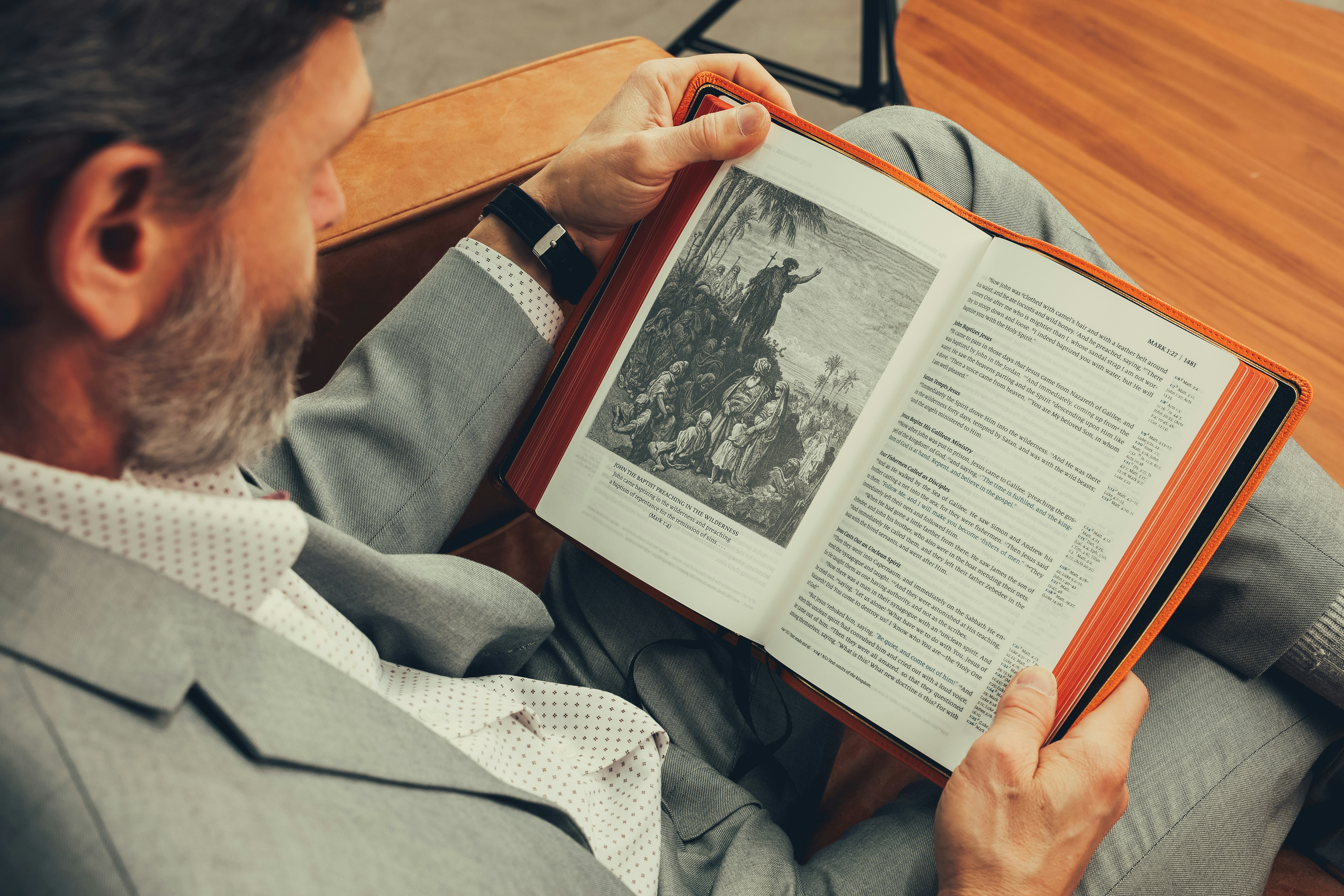 A man sitting in a chair reading a book