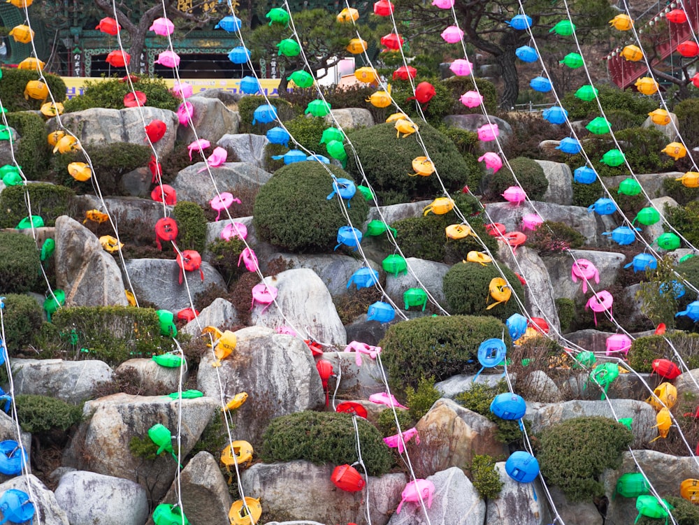 a bunch of colorful balls are tied to a rock wall