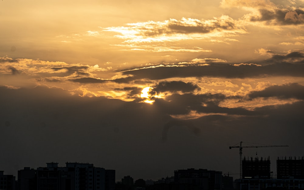 the sun is setting over a city with tall buildings