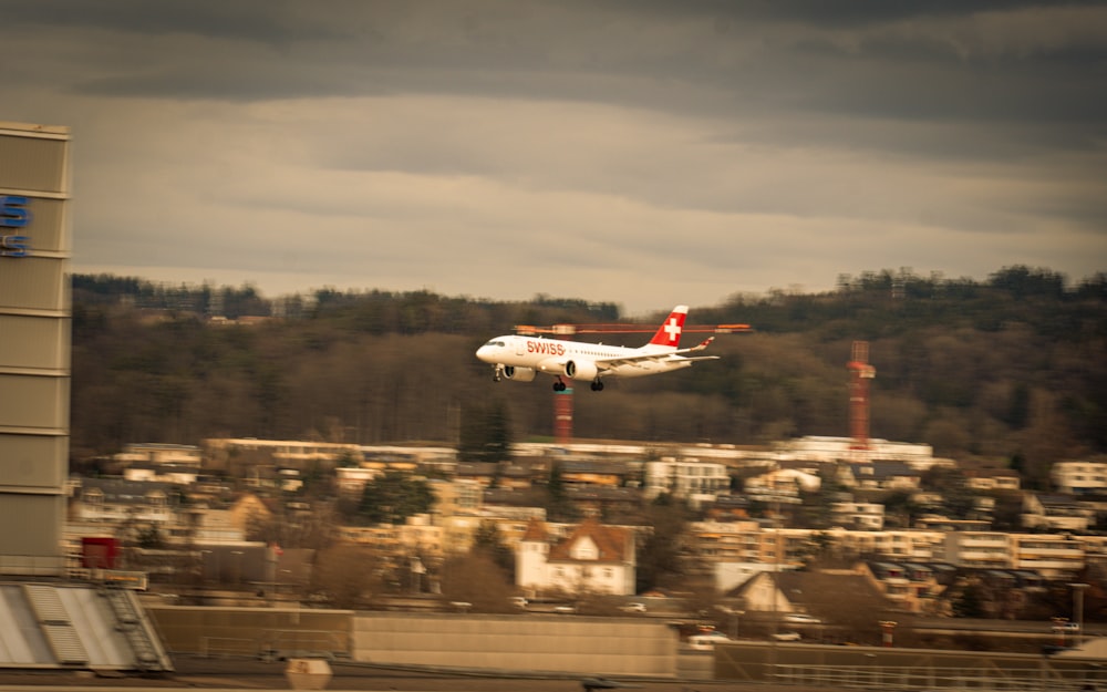 a small plane flying over a city under a cloudy sky