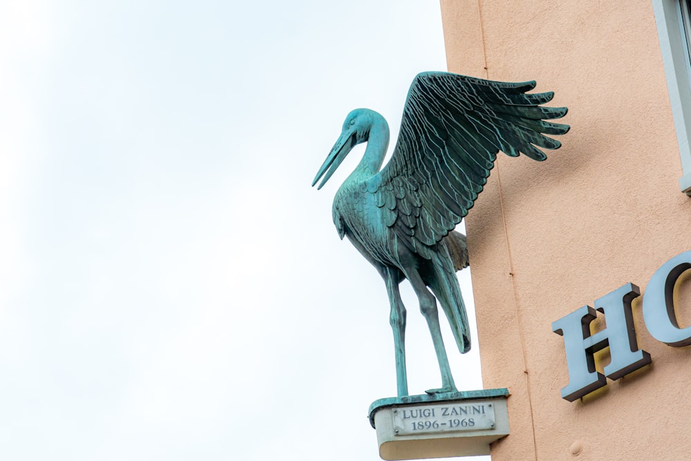 a statue of a bird on top of a hotel sign