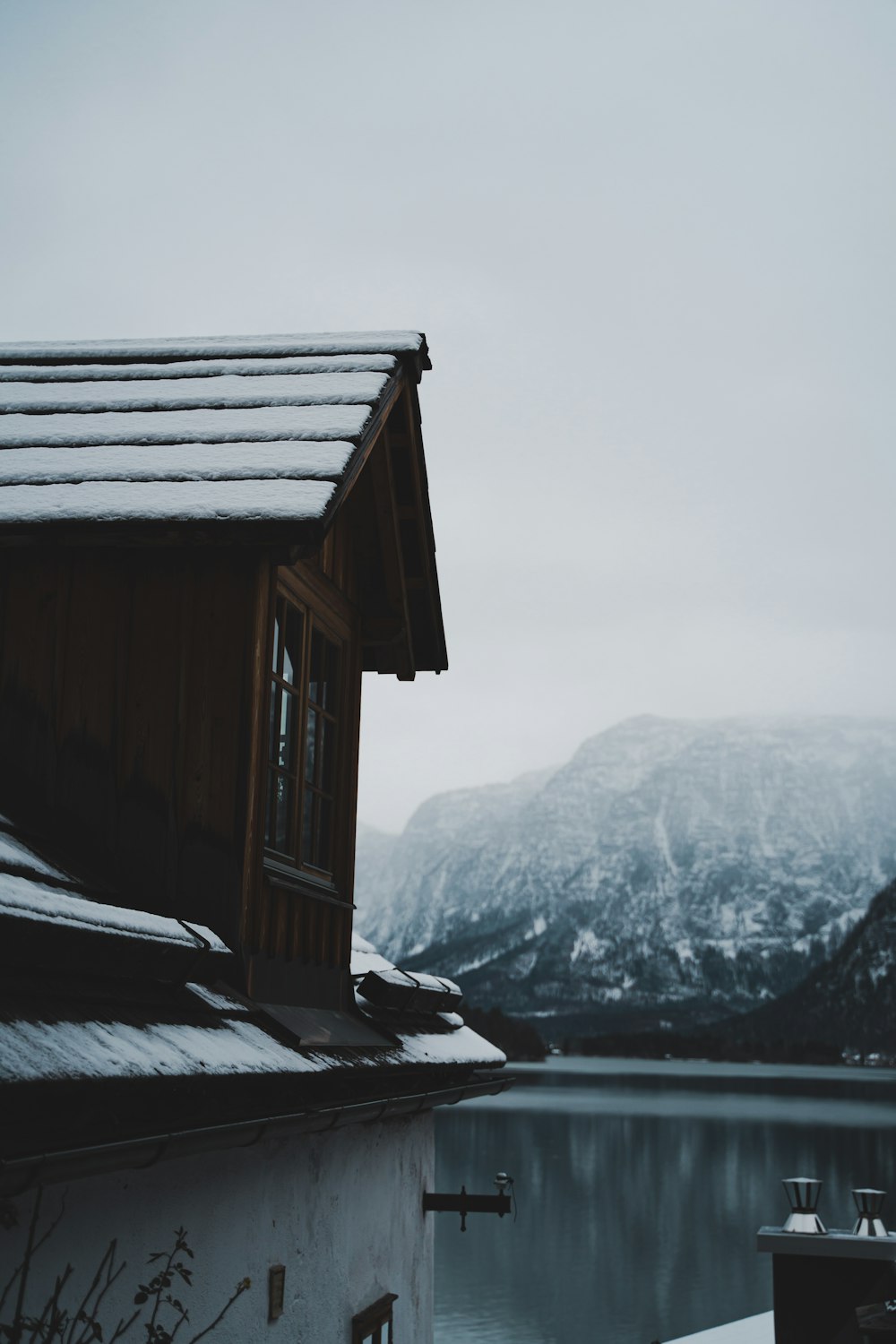 una casa asentada en la cima de una ladera cubierta de nieve