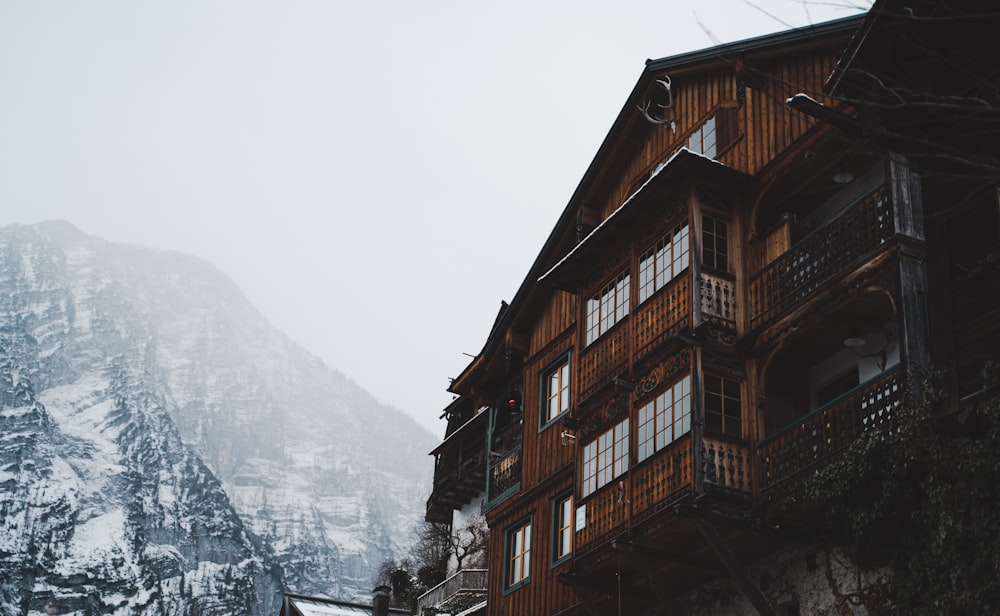 a tall wooden building sitting next to a snow covered mountain