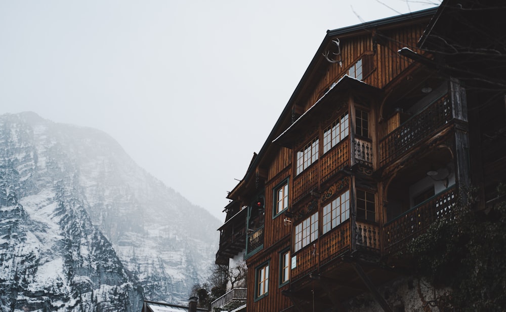 un alto edificio de madera sentado junto a una montaña cubierta de nieve