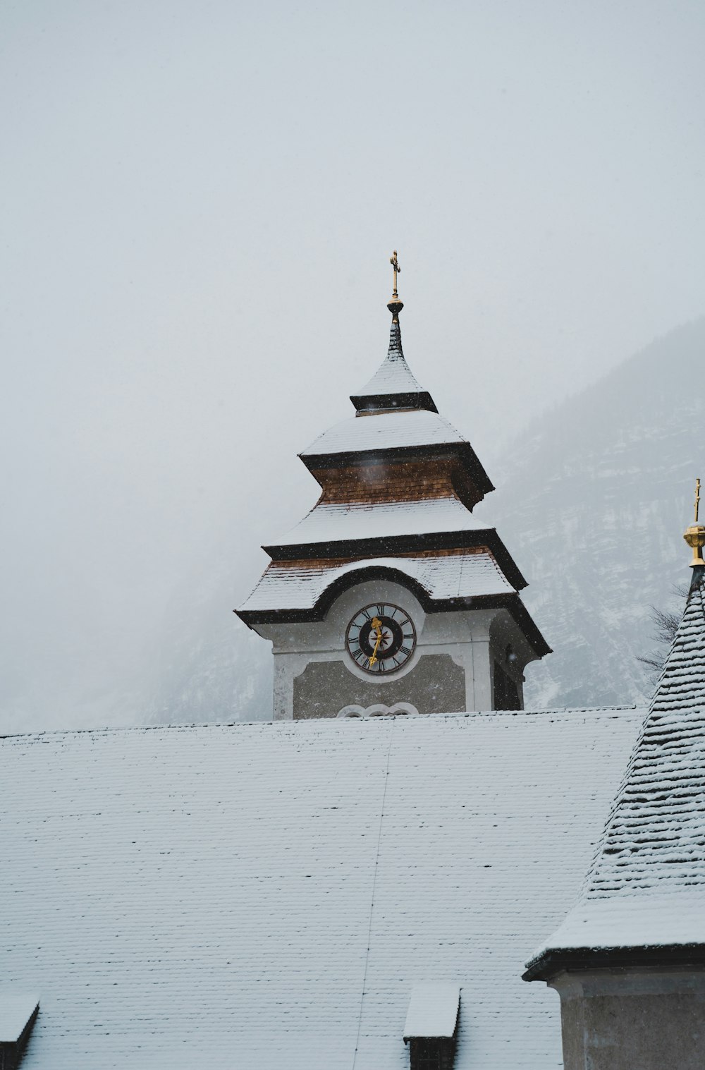 una torre de reloj en lo alto de un edificio cubierto de nieve