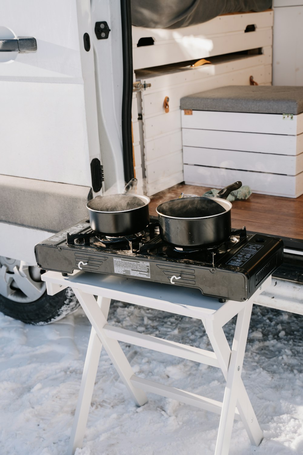 a camper with two pots and pans on the stove