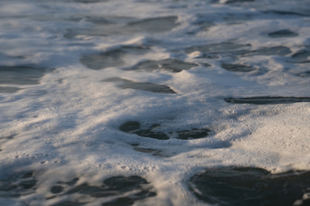 a close up of water with footprints in it