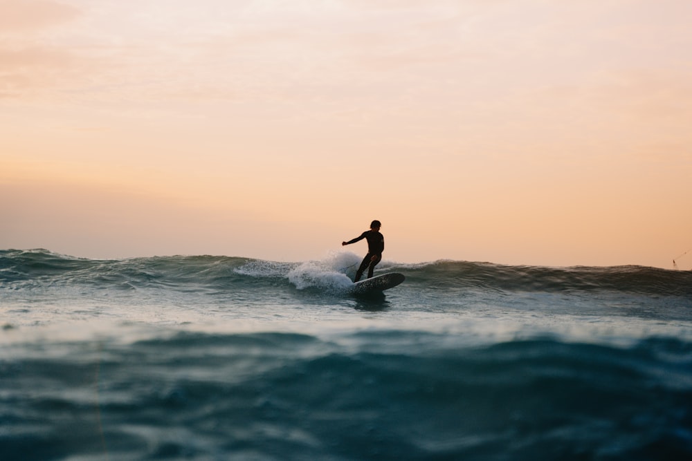 ein Mann, der auf einer Welle auf einem Surfbrett reitet