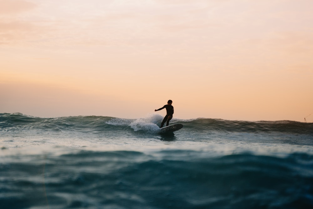 a man riding a wave on top of a surfboard