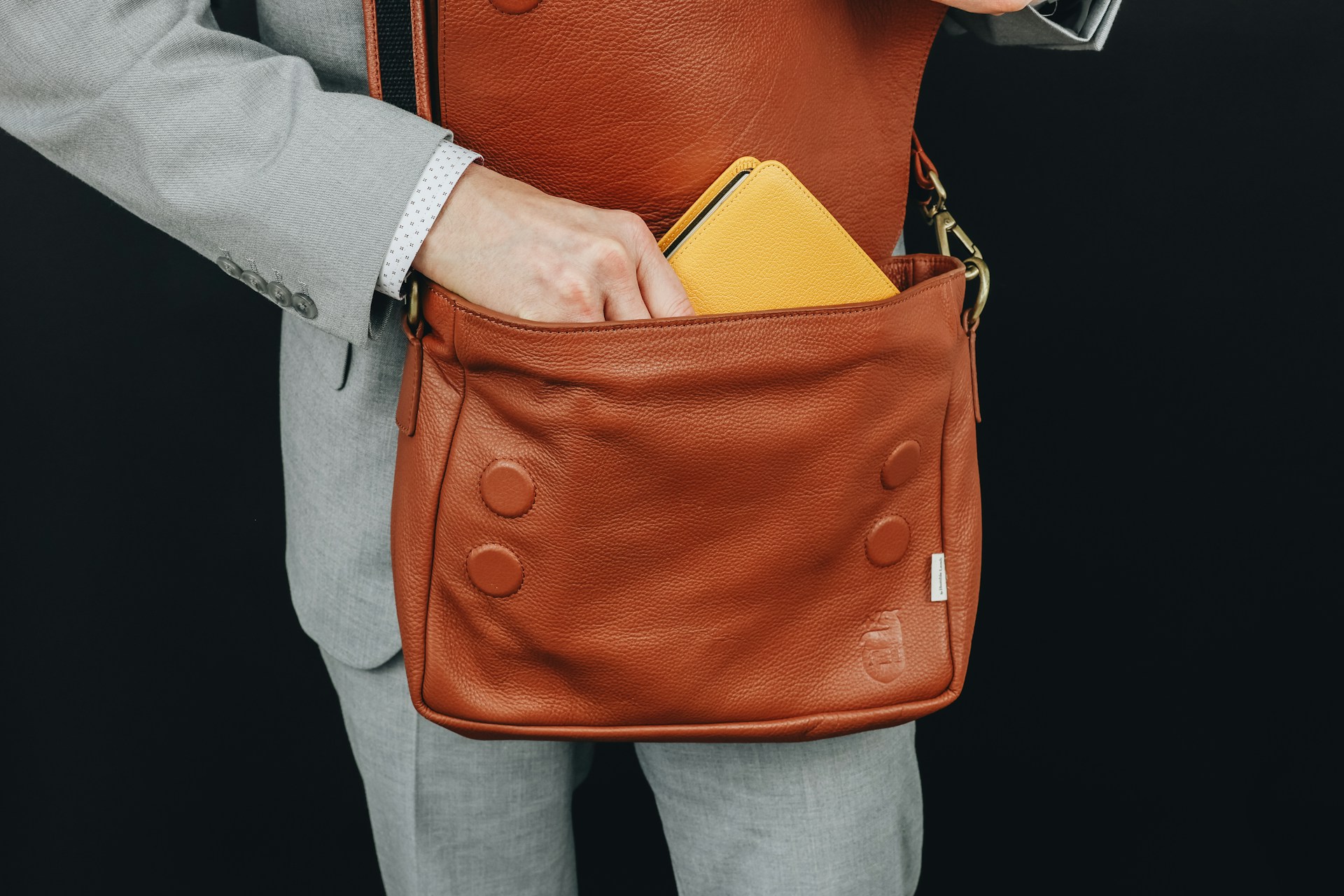 A man in a suit holding a brown bag