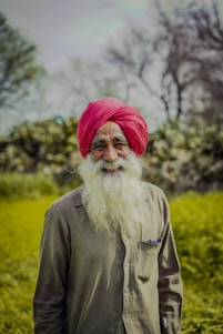 A man with a red turban standing in a field