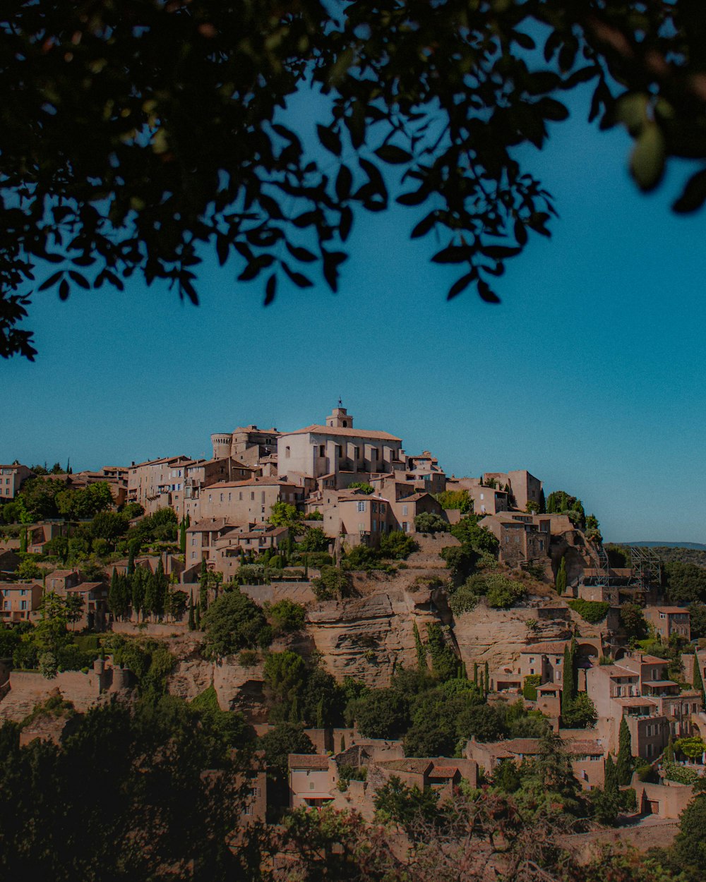 a village on top of a hill surrounded by trees