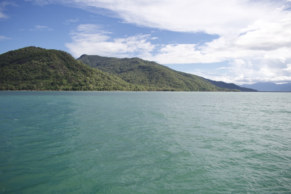 a large body of water with a mountain in the background