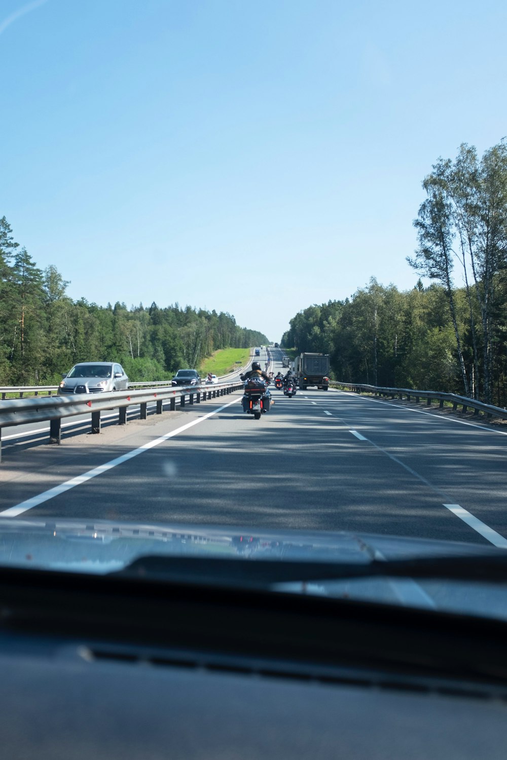 a car driving down a highway next to a forest